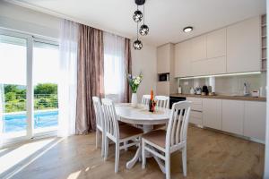 a kitchen and dining room with a table and chairs at Villa Aurora in Gorovići