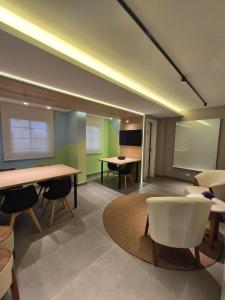 a meeting room with tables and chairs and a tv at Studio Novo e completo perto da PUC in Curitiba
