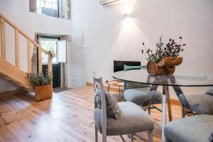 a dining room with a glass table and chairs at Casa do Adro in Idanha-a-Nova