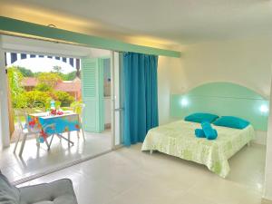 ein Schlafzimmer mit Bett und Tisch und ein Balkon in der Unterkunft Studio Petite Plage - Pieds dans l'eau in Sainte-Anne