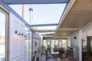 a conservatory with a glass ceiling and tables and chairs at Hotel Makedonia in Évzonoi +29 photos