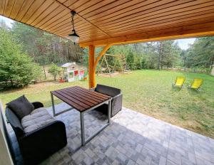 a screened in porch with a table and chairs at Luksusowy dom w sosnowym lesie in Płaska