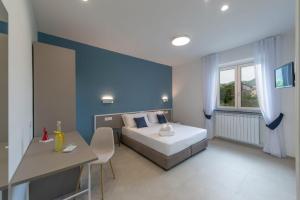 a bedroom with a bed and a blue wall at Rossy Palace - Amalficoast Suites in Agerola