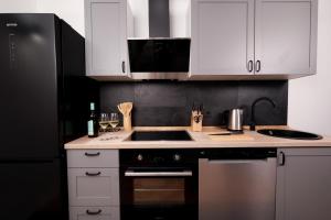 a kitchen with white cabinets and a black refrigerator at Studio 1833 in Michelstadt