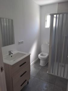 un bagno con un lavandino bianco e un water di Triana y mar a Roda de Bará