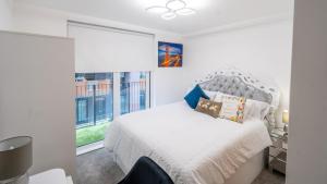a bedroom with a white bed and a window at Mega7 Luxury 2bedrooms Apartment - 2baths, 3toilets plus Balcony and Free Car park in Manchester