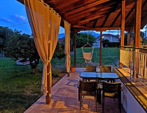 a patio with a table and chairs and a hammock at Summer House Rocinante 2 in Vromerí