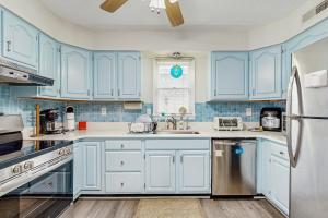 a blue kitchen with a sink and a refrigerator at Beach Retreat in Ocean City
