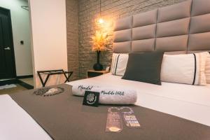 a bedroom with a large bed with two pairs of slippers at Mandala Medellín Belén By GyC Hotels in Medellín +17 photos