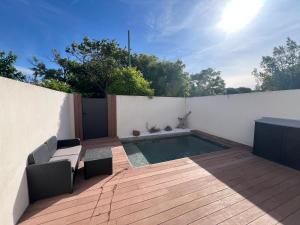 a patio with a swimming pool and a wooden deck at Villa JOPI 3Ch piscine plage entierement climatisée in Le Grau-dʼAgde
