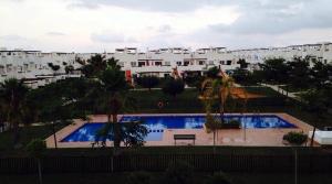 a large swimming pool with a bench and some buildings at Murcia Golf & Holidays Apartment in Alhama de Murcia