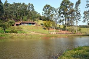 a house on a hill next to a lake at Pousada Santa Teresa in São Miguel dʼOeste