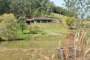 a house sitting on top of a hill next to a lake at Pousada Santa Teresa in São Miguel dʼOeste