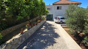 a stone retaining wall with potted plants and a car at Apartment Mila in Brna