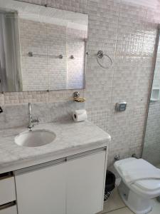 a bathroom with a sink and a toilet and a mirror at Condomínio CTC Araras, Caldas Novas - VPC in Caldas Novas