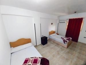 Un dormitorio con dos camas y una cortina roja. en Crystal Palace, en Luxor