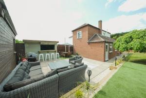 a backyard with a couch and a grill at The Machine House - Hot Tub - Outdoor Bar in Ashby de la Zouch