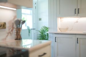 a kitchen with white cabinets and a counter top at The Machine House - Hot Tub - Outdoor Bar in Ashby de la Zouch +32 photos