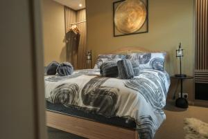 a bed with blue and white sheets and pillows at The Machine House - Hot Tub - Outdoor Bar in Ashby de la Zouch