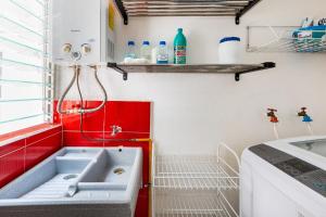 a small kitchen with a sink and red cabinets at Departamento Completo Coapa Mexico Lindo y Querido in Mexico City +19 photos