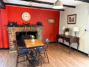 a room with a fireplace and a table and a clock at The Cottage Inn in Llandeilo +14 photos