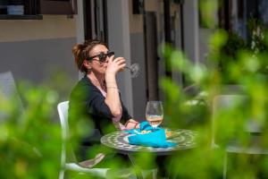 a woman sitting at a table drinking a glass of wine at Rossy Palace - Amalficoast Suites in Agerola +24 photos
