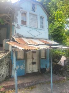 Kupuiscome zone u will always remember的一座前面有遮阳篷的老房子