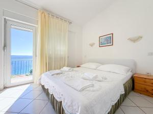 a bedroom with a bed and a large window at House Ursić in Brela