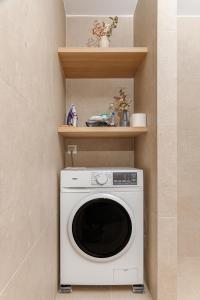 a washer and dryer in a corner of a room at Kefalas Luxury Villas Kelari Accessible Stone Studio in Epáno Kefalás