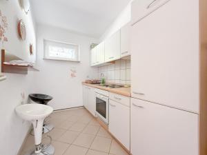 a white kitchen with white cabinets and a sink at House Ursić in Brela