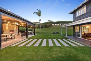 Un gran patio trasero con terraza y césped. en The Ranch, en Surfdale