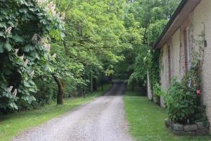 a dirt road next to a house with trees at Millvale Cottage in Cootehill