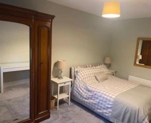 a bedroom with a bed and a table with a mirror at Millvale Cottage in Cootehill