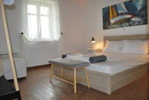 a bedroom with a bed with a table and a window at Blue Island Maisonette with Sharing Pool in Mýkonos City