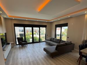 a living room with a couch and chairs and windows at Villa Mia - 4 km to the sea 9 km to the airport in YeÅŸilkÃ¶y