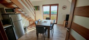 Un comedor con una mesa y un refrigerador. en Apartmán Hluchá sova, en Horní Václavov