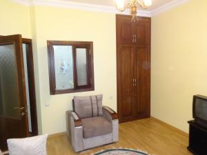 uma sala de estar com uma cadeira e uma televisão em Buoy Rooms em Batumi