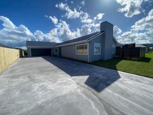 a large driveway in front of a house at Palm Retreat - Whitianga in Whitianga