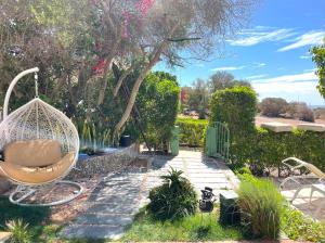 a garden with a swing and some plants at A7 Maison Blanche Imi ouaddar in Agadir