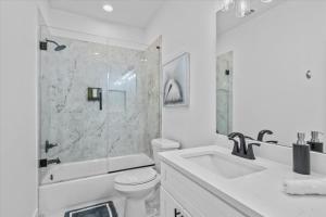 Un baño blanco con inodoro y lavabo. en High Style in H-Town with Luxury near Downtown, en Houston 49 fotos más