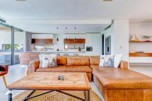 ein Wohnzimmer mit Sofa und Tisch in der Unterkunft Oceans Edge 4, Zimbali Estate by Euphoric Leisure in Ballito