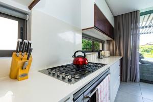 einen Wasserkocher mit rotem Tee auf einem Herd in der Küche in der Unterkunft Oceans Edge 4, Zimbali Estate by Euphoric Leisure in Ballito + 30 Fotos