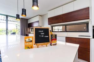 eine Küche mit einem Kreidetafelschild auf einer Theke in der Unterkunft Oceans Edge 4, Zimbali Estate by Euphoric Leisure in Ballito