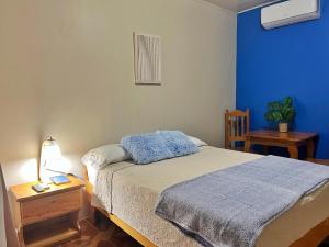 a bedroom with a bed and a blue wall at Hotel Sueño de Luna in Tapantí