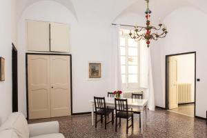 uma sala de jantar com uma mesa e cadeiras e um lustre em Casa Carducci - Spacious historical home close to the beach em Imperia