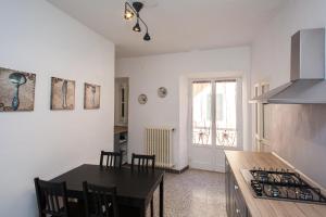 インペリアにあるCasa Carducci - Spacious historical home close to the beachの白い壁のキッチン(テーブル、椅子付)