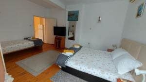 a bedroom with a bed and a tv in it at Вила Радеви in Obzor