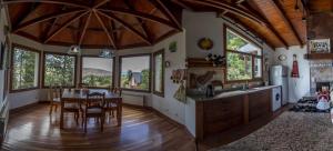 a kitchen and dining room with a table and some windows at Altos de Esquel in Esquel
