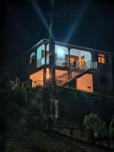 a house with a balcony on the side of it at night at Mamie Kaz in Vieux-Habitants