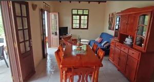 a living room with a wooden table and chairs at Mamie Kaz in Vieux-Habitants